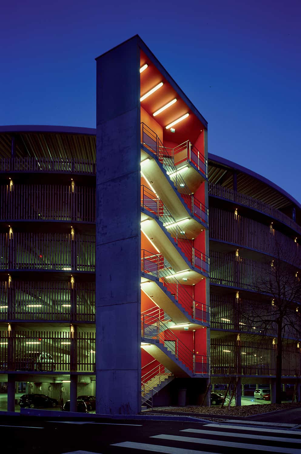 photographie d'architecture de nuit d'un parking avec un accès par un grand escalier extérieur illuminé © francois nussbaumer