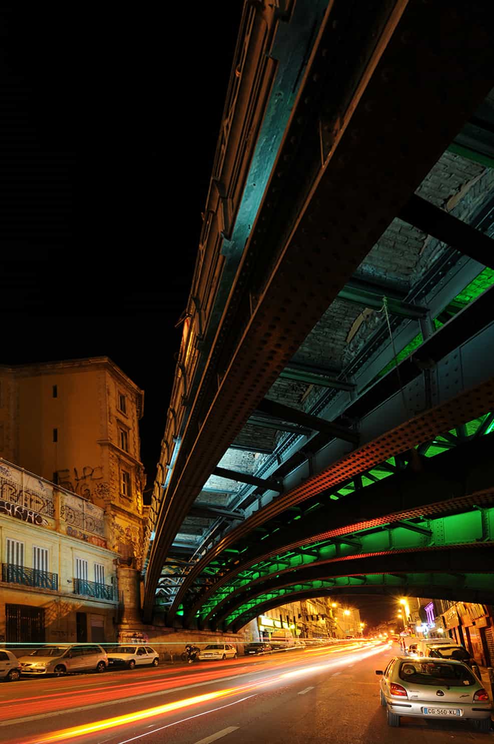 photographie d'architecture de nuit d'une route passsant sous un pont éclairé © francois nussbaumer