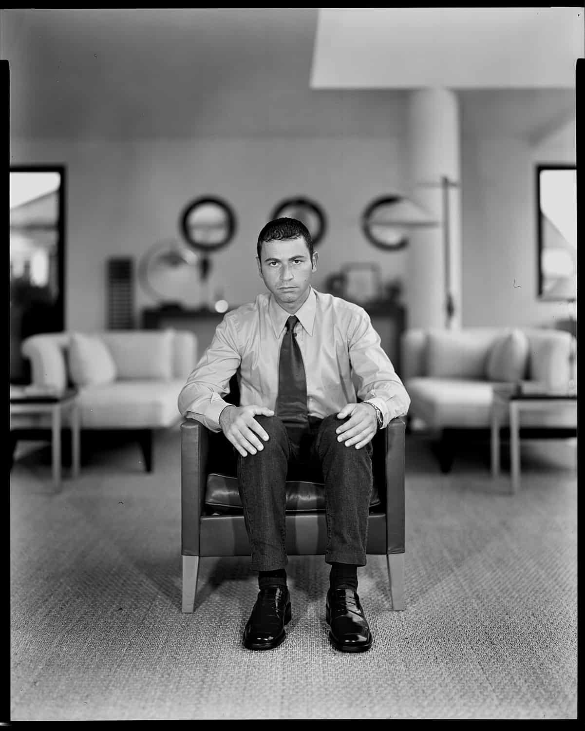 photo noir et blanc d'un promoteur assis sur un fauteuil © francois nussbaumer