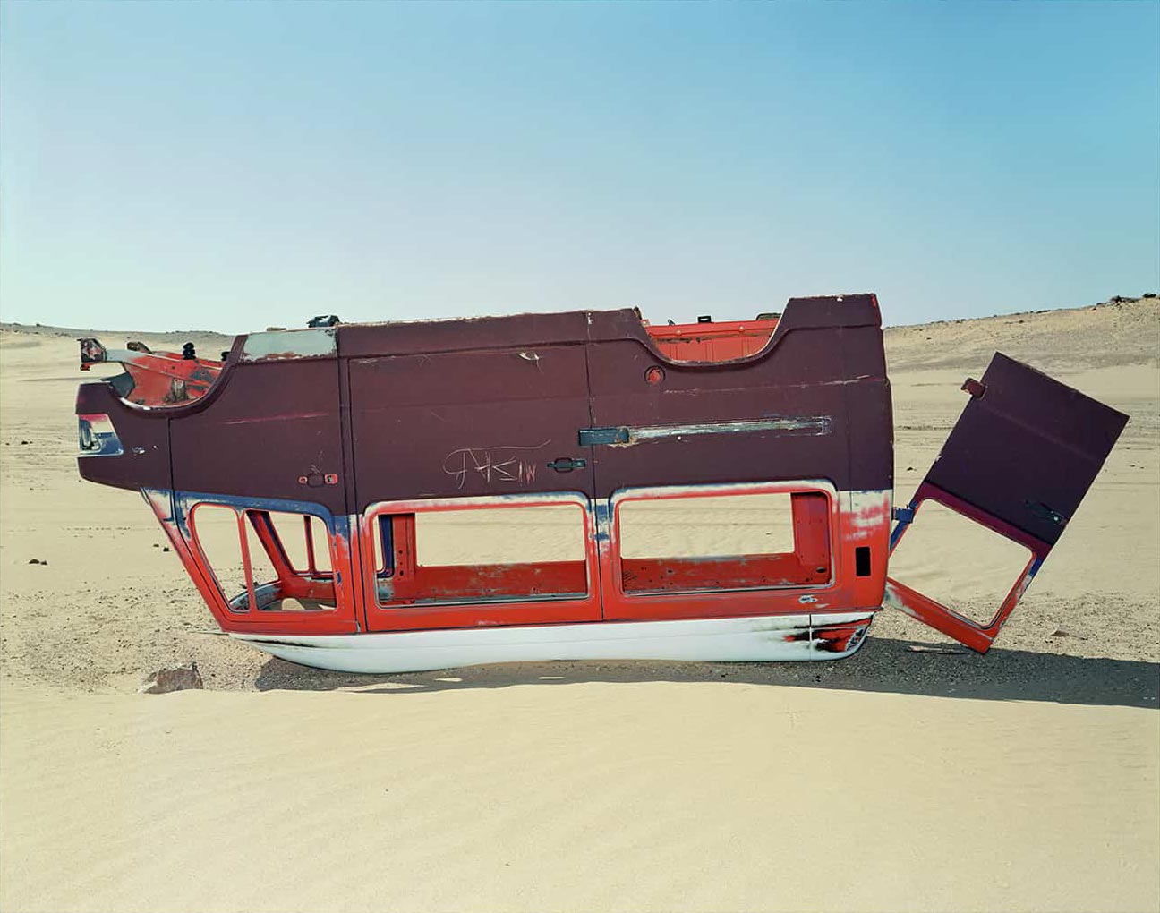 photographie d'une carcasse d'un van dans le désert © francois nussbaumer