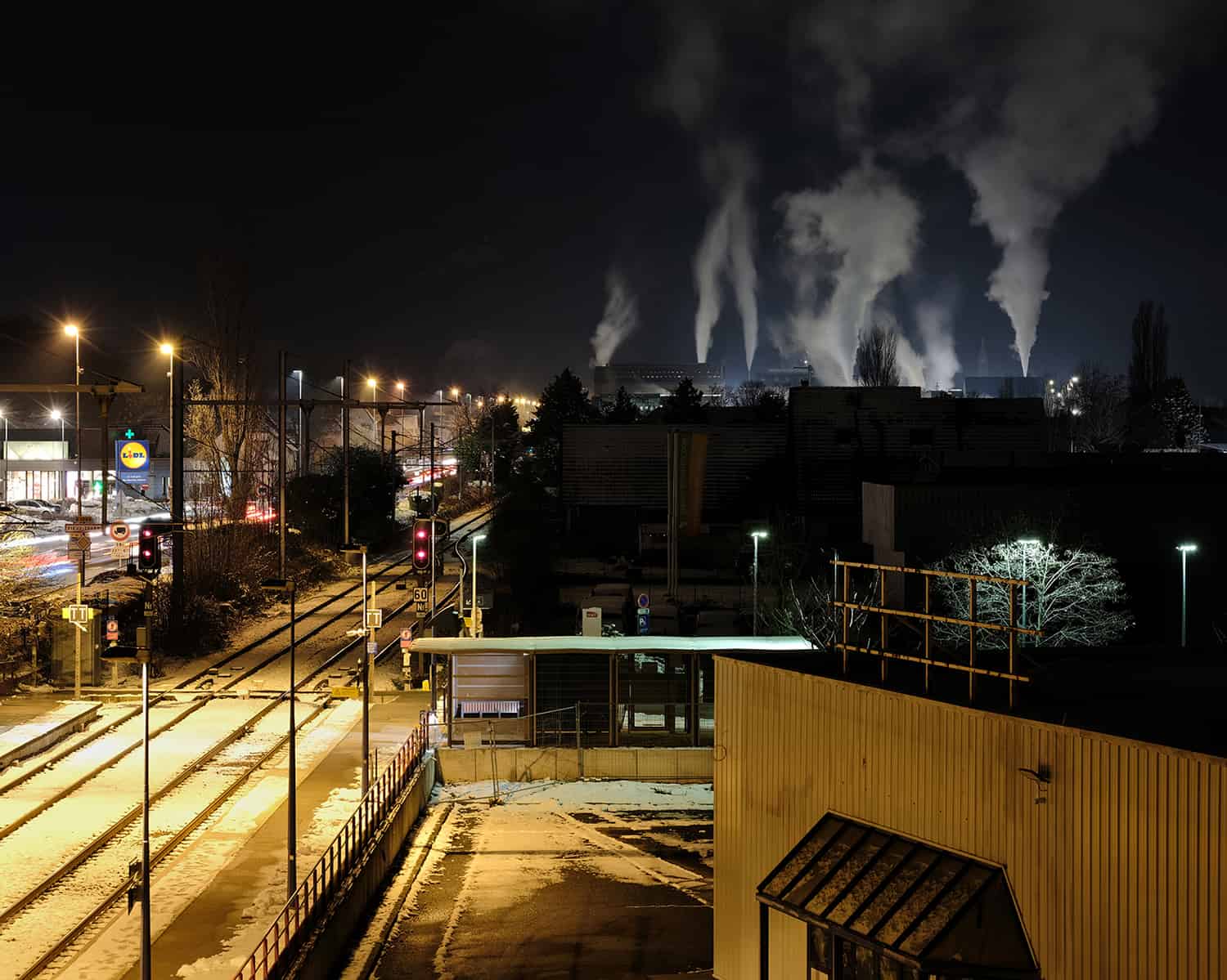 photographie d'une zone industrielle en hiver avec de la fumée se dégageant des usines © francois nussbaumer